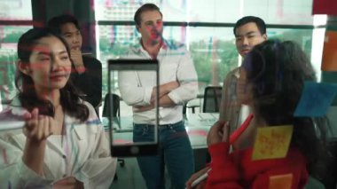 Profesyonel iş adamları, cam duvarda yaratıcı fikirleri paylaşmak için yapışkan notlar kullanarak pazarlama fikrini araştırıyor. Bir grup farklı iş adamları strateji hakkında tartışıyorlar. - Yakın çekim. Yönlendirici.