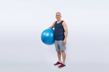 Vücut uzunluğu tam, atletik ve sportif son sınıf öğrencisi izole arka planda ayakta duran topa egzersiz yaptırıyor. Emeklilikten sonra sağlıklı ve aktif bir yaşam tarzı. Etki