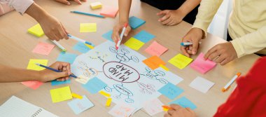 Profesyonel başlangıç grubu zihin haritası kullanarak yaratıcı pazarlama fikrini paylaşıyor. Genç yetenekli iş adamları yapışkan notlar yazarken beyin fırtınası planı yapıyorlar. Eline odaklan. - Yakın çekim. Değiştirilmiş.