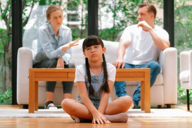 Stresli ve mutsuz bir genç kız oturma odasında ebeveyninin tartışması yüzünden gerginlik içinde ağlıyor. Sağlıksız ev hayatı ve travmatik çocukluk depresyona dönüşür. Eşzamanlama