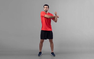 Vücut uzunluğunun tamamı atletik ve sportif genç bir adam tarafından izole edilmiş arka planda egzersiz öncesi duruş için ısınma ve esneme hareketleri ile çekilir. Sağlıklı aktif ve vücut bakımı yaşam tarzı.