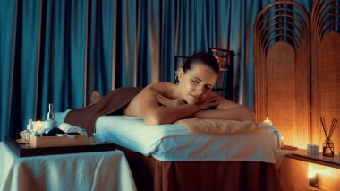 Beyaz kadın müşteri stres önleyici spa masajının keyfini çıkarıyor ve lüks otel ya da otelde sıcak mum ışığında güzellik teniyle eğleniyor. Sessiz.