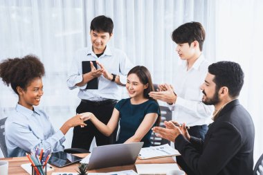 Çeşitli iş arkadaşları başarıyı şirket işyerindeki el sıkışma ve takım çalışmasıyla kutluyor. Çok kültürlü, mutlu profesyonellerden oluşan bir ekip ofiste tokalaşarak birlik oldular. Uyum
