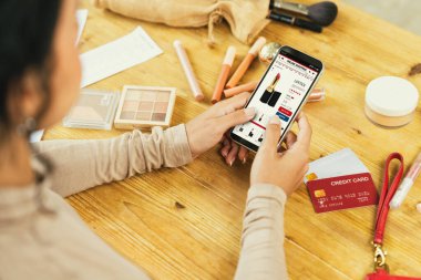 İnternet pazarından alışveriş yapan kadın modern yaşam tarzı için satış malzemeleri arıyor ve önemli siber güvenlik yazılımları tarafından korunan cüzdandan çevrimiçi ödeme için kredi kartı kullanıyor