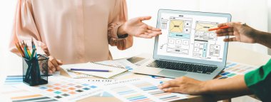 İç tasarımcının kırpılmış resmi renk örneklerinden renk sunarken, dizüstü bilgisayar cep telefonu uygulaması ve web sitesi için wirefram tasarımları sergiliyor. Yaratıcı tasarım ve iş konsepti. Değiştirilmiş.