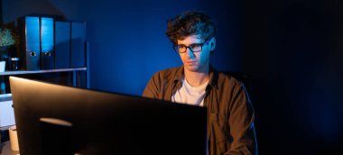 Panorama View 'daki neon ışıklı modern ofiste yaratıcı bir girişim için bilgisayara odaklanan genç işadamı. Düşünüyorum da, pazarlama ağı yaratıcıdan pazar kanalı tasarım konseptine çevrimiçi planlama. Toplayıcı.