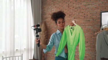 Kadın nüfuzlu kişi canlı yayında video görüntülerini çekiyor. Kıyafetler sosyal medya ya da blog için çok önemli. Stüdyo ışıklandırmalı mutlu genç kız çevrimiçi pazarlama oturumu yayını için..