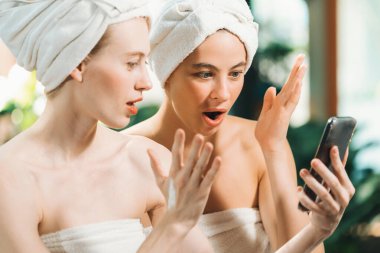 Beyaz havluyla güzel ciltli bir çift güzel kadın açık havada barışçıl doğal çevreyle çevrili bir şekilde fotoğraf çekiyorlar. Güzellik ve sağlıklı spa konsepti. Huzur.