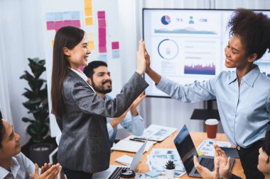 Çeşitli işletme ekipleri, kurumsal ofis toplantısında başarılı bir beşlik çakma ve mutluluk ifadeleri ile yapılan toplantıyı birlik başarısı ve profesyonel bütünlüğü temsil ederek kutluyorlar. Uyum