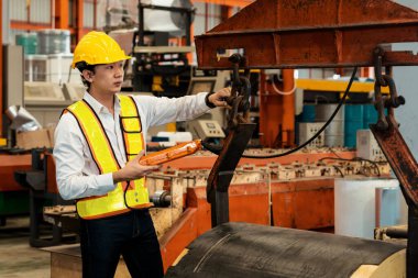 Makine operatörü çelik üretim makinelerini ustalıkla çalıştırıyor, metal fabrikasındaki ağır inşaat mühendisliği malzemeleri için silindir rulo çelik üretiyor. Örnek gösteriliyor