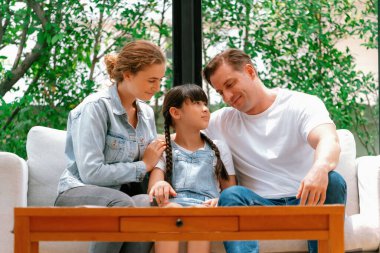 Ebeveynler kızlarını sevgi dolu kucaklaşmalarla rahatlatıyorlar, onun güvende ve korkudan korunmasına yardım ediyorlar, başını omzuna yaslıyorlar. Mutlu aile sevgisi ve çocuk bakımı konsepti. Eşzamanlama