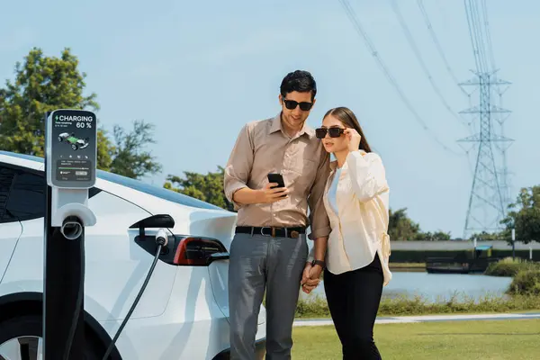Paar Betalen Voor Elektriciteit Met Smartphone Terwijl Opladen Auto Batterij — Stockfoto