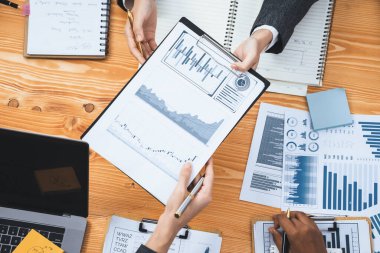 Analist ekibiyle düz görünüm çalışma alanı ahşap masası işletme stratejisi planlamak için BI gösterge paneli verilerini kullanın. İş adamları pazarlama göstergesi olarak FIntech 'in veri analizini kullanır. Uyum