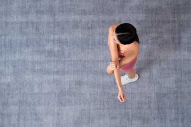 Spor giyimli çekici Asyalı kadın spor egzersizlerinden önce esneme hareketleri yapıyor. Sağlıklı atletik bir kadınla vücut egzersizi. Üst Manzara Panoraması. Kuvvetli