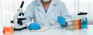 Laboratuvar araştırmacısı laboratuvar tüpünde renkli kimyasal sıvı kullanarak yeni ilaç ya da tedavi geliştirir. Laboratuvar ekipmanları ile bilimsel uzmanlık ile sağlık hizmetlerinin teknolojik gelişimi. Panorama Katı