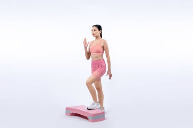 Çalışkan, enerjik bir kadın atölyede egzersiz yapıyor. Kardiyo aerobik hareketleriyle izole bir arka plan. Genç atletik Asyalı kadın mahareti ve dayanıklılık eğitimi konsepti.