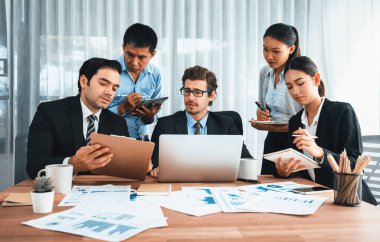 Ofis masasındaki finansal veri raporlarını analiz eden çeşitli bir grup iş analisti. Stratejik pazarlama planlaması için iş istihbarat analizine göre grafikler ve grafikler.