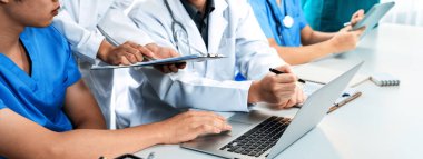 Hastane masasında birlikte çalışan ve tıbbi tedavi planlayan profesyonel tıbbi ekip. Takım çalışması başarılı hastalıklara ve hastalıklara yol açar. Panorama Katı