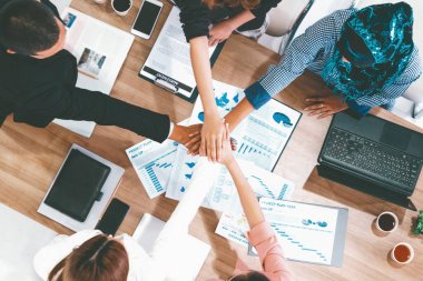 İş adamları ve iş kadınları, takım çalışması, destek ve iş birliğini gösteren çok kültürlü ofis odasındaki grup toplantılarında el ele tutuşuyorlar. Çeşitli işyerleri ve şirket çalışanları konsepti. uds