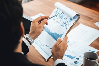 Ofis masasındaki finansal veri raporlarını analiz eden çeşitli bir grup iş analisti. Stratejik pazarlama planlaması için iş zekası analizi çizelgesi ve grafiği.