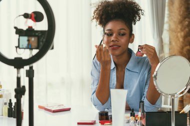Kadın nüfuzlu kişi canlı yayında video görüntülerini çekiyor. Makyaj çok önemli sosyal medya ya da blog. Kozmetik stüdyosu ışıklandırmalı mutlu genç kız çevrimiçi pazarlama oturumu yayını için..
