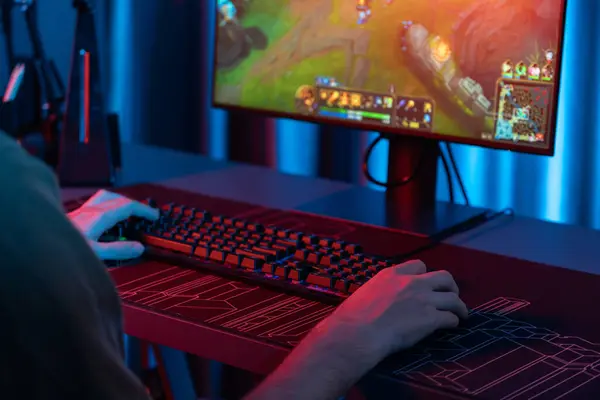 stock image Cropped host channel of young gaming streamer playing fighting Moba at battle arena game with multiplays team on blurred pc screen with back side image at neon digital light modern room. Gusher.