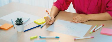 Profesyonel iş kadını iş dünyasının zihin haritasını çiziyor. Yaratıcı kadın girişim lideri, fikir üretmek için kalem ve yapışkan notlar kullanarak pazarlama planları hazırlıyor. - Yakın çekim. Eline odaklan. Değiştirilmiş.