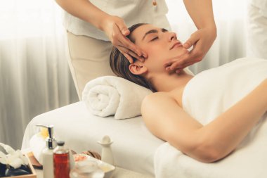 Kafkasyalı kadın stres önleyici kafa masajından ve lüks tatil beldesi ya da otel spa salonundaki modern ışık ortamında yüz güzelliği eğlencelerini şımartmaktan hoşlanıyor. Sessiz.