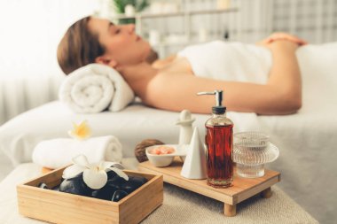 Aromaterapi masajı gündüz atmosferinde ya da spa salonunda bulanık bir kadına odak dekor ve spa aksesuarları kurarak tatil köyünde ya da otel arka planında keyifli aroma spa masajı yapan bir masaj. Sessiz.