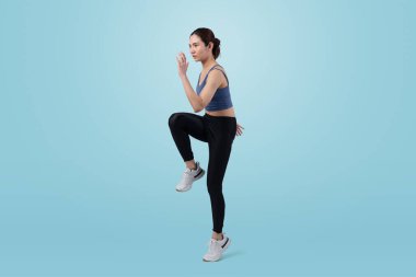 Yan bakış genç atletik Asyalı kadın stüdyoda koşu pozisyonu aldı izole bir arka planda çekim yaptı. Sağlıklı vücut fiziği ve vücut egzersizi yaşam tarzı konsepti. Kuvvetli