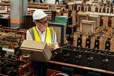 Fabrika mühendisi endüstriyel çelik oluşum makinesini teftiş ediyor. Metal makine mühendisliği denetim denetçisi olarak liderliği gösteriyor..