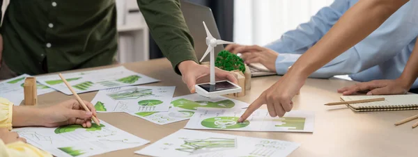 風車のモデルは再生可能エネルギーを表し シティを表す木製のブロックは環境文書の散乱で緑のビジネス ミーティング テーブルに置かれました フロントビュー デリネーション — ストック写真