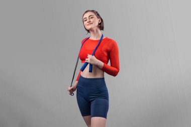 Vücut uzunluğunun tamamı atletik ve sportif genç bir kadın tarafından izole edilmiş arka planda ip atlarken çekildi. Sağlıklı aktif ve vücut bakımı yaşam tarzı.