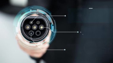 Kameranın önüne odaklanmış EV şarj cihazı fütüristik akıllı dijital EV batarya durum hologramını gösteriyor. EV araba şarjı sürdürülebilir güç için alternatif enerji kullanıyor. İnceleyin