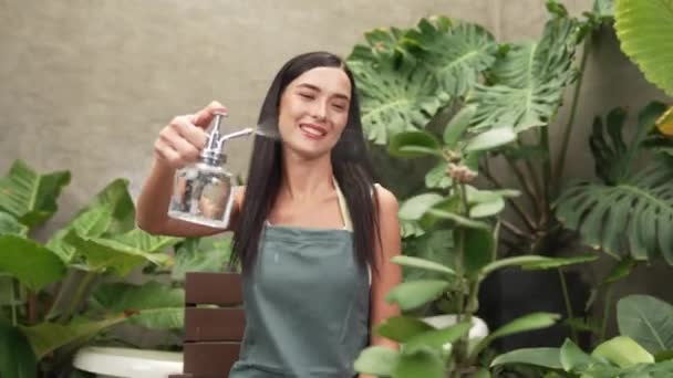 Молодая Женщина Садовница Ухаживает Тропическим Растением Нежно Поливает Минималистском Архитектурном — стоковое видео