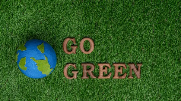 Go green and save the world with environment friendly effort. The message Go Green letters arranged to promote eco awareness for sustainable future with biophilc design background. Gyre
