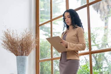 Klinikteki psikolog kadın. Profesyonel portresi. Dostane gülümsemesiyle hastayı psikoloğa davet ediyor. Deneyimli ve kendinden emin psikolog çok önemli bir uzmandır.
