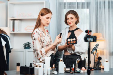 Kadın Etkilenen Vlog video görüntülerini sosyal medya ya da blog 'da en üst düzeyde yayınlıyor. Kozmetik stüdyosu ışıklandırmalı mutlu genç kız çevrimiçi pazarlama oturumu yayını için..