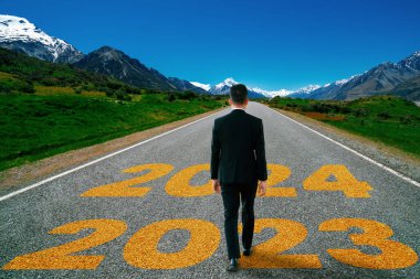 2024 yılbaşı yolculuğu ve gelecek vizyon konsepti. 2024 'ün başında mutlu bir yeni yıl kutlaması için otoyolda ilerleyen iş adamı mutlu ve başarılı bir başlangıç yapacak. .