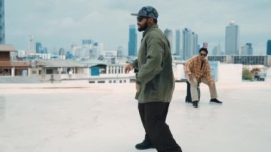 Profesyonel break dans takımı çatıda çok kültürlü arkadaşlar varken break dans alıştırması yapıyor. Genç modern dans grubu hip hop hareketi yapıyor. Tarz, moda, aksiyon. Açık hava sporu 2024 hiphop..