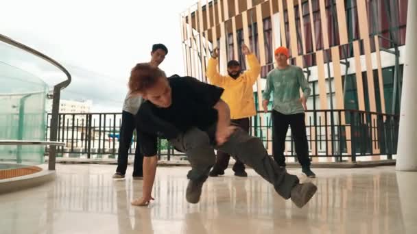 回廊モールのヒップホップ音楽に足跡を移動するヒップスターのグループ 熟練したブレイクダンサーは 多文化の友人やダンサーグループに囲まれてBボーイダンスを行います アウトドアスポーツ 2024 ヒップホップ — ストック動画