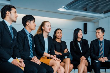 Genç Asyalı ve Kafkas dinleyiciler ofiste grup toplantısını dinliyorlar. İş adamları ve iş kadınları eğitim atölyesinde. Uluslararası çok kültürlü iş. uds