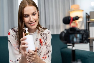 Kadın Etkilenen Vlog video görüntülerini sosyal medya ya da blog 'da en üst düzeyde yayınlıyor. Kozmetik stüdyosu ışıklandırmalı mutlu genç kız çevrimiçi pazarlama oturumu yayını için..