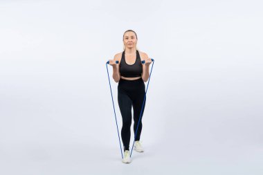 Vücut uzunluğu tam, atletik ve sportif yaşlı kadın izole edilmiş arka planda halat egzersizi yapıyor. Sağlıklı aktif fizik ve vücut bakımı son sınıf öğrencileri. Etki