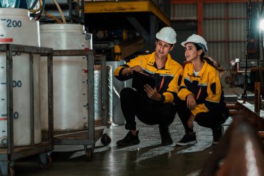 İki fabrika işçisi veya mühendis, kimya fabrikası, kimya fabrikası işyeri ve endüstriyel meslek konseptinde makine veya prosedür üzerinde profesyonel teftiş yürütüyor. Örnek gösteriliyor