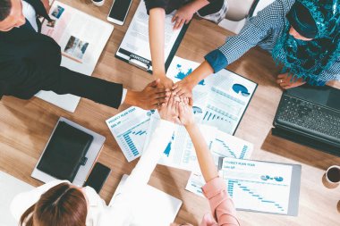 İş adamları ve iş kadınları, takım çalışması, destek ve iş birliğini gösteren çok kültürlü ofis odasındaki grup toplantılarında el ele tutuşuyorlar. Çeşitli işyerleri ve şirket çalışanları konsepti. uds