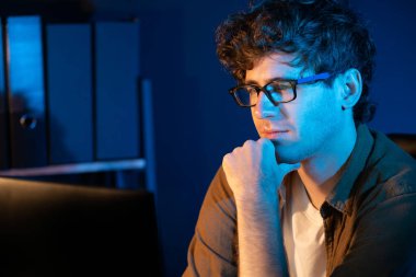 Genç işadamı, Neon Light Modern Ofis 'te yaratıcı bir başlangıç projesi için bilgisayara odaklanıyor. Düşünüyorum da, pazarlama ağı yaratıcıdan pazar kanalı tasarım konseptine çevrimiçi planlama. Toplayıcı.