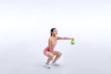 Dinç, enerjik bir kadın izole edilmiş arka planda ağırlık kaldırma egzersizi yapıyor. Genç atletik Asyalı kadın dayanıklılığı ve dayanıklılık eğitimi rutin vücut egzersizi..