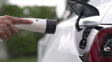 Elle şarj EV şarj prizi tutucusu elektrikli arabaya bağlanıyor, EV araba aküsünü temiz çevre için sıfır CO2 emisyonu ile alternatif ve sürdürülebilir enerjiyle şarj ediyor. Titiz