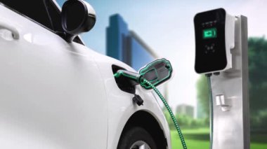 Yeşil Şehir Parkı 'ndaki ekolojik temiz enerji şarj istasyonundan gelen fütürist akıllı EV şarj aletinin şarj ettiği elektrikli araba. Alternatif enerji kullanan gelecekçi elektrikli araba. İnceleyin